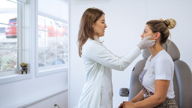 Dermatóloga revisando la piel de una mujer.