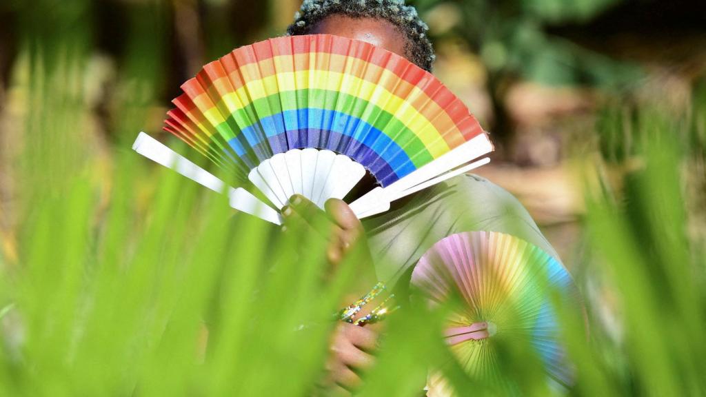 Un mujer africana sostiene un abanico con los colores de la bandera LGTBI en una imagen de archivo,