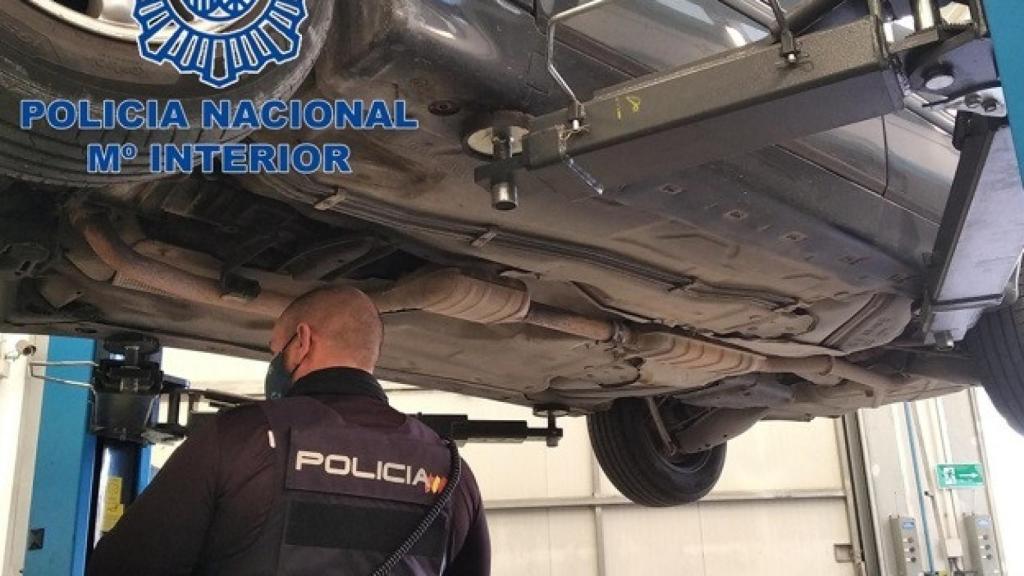 Agentes de la Policía Nacional vigilan los bajos de un vehículo.
