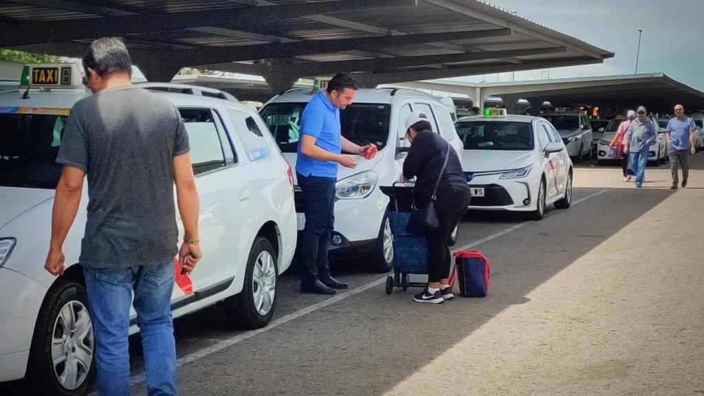 Una mujer le vende una bebida a un taxista.