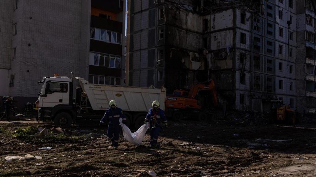 Dos hombres trasladan un cadáver tras el bombardeo ruso en Uman este viernes.