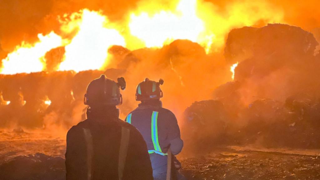 Dos bomberos en el lugar del incendio en la planta de reciclaje de Colmenar Viejo.