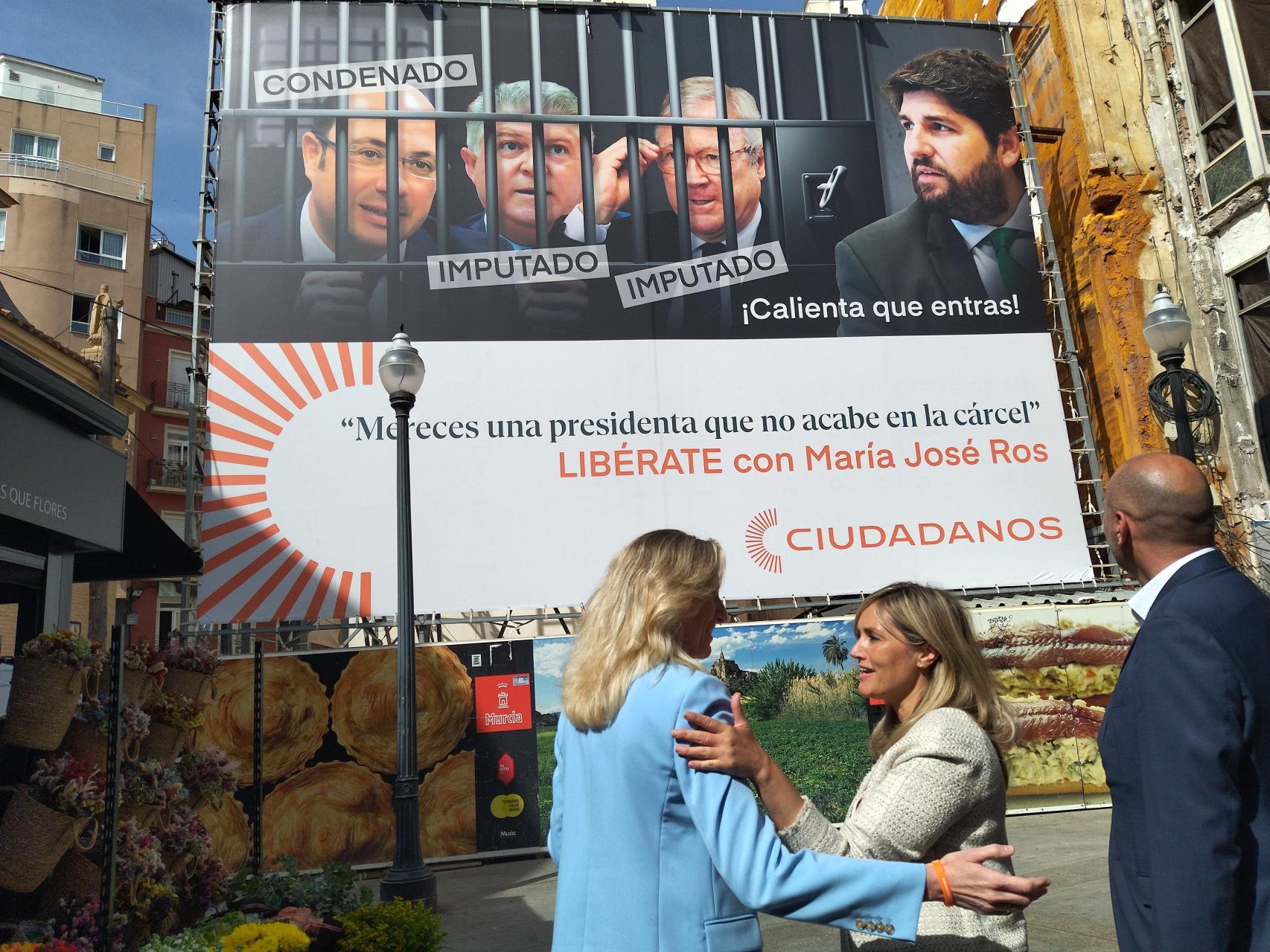 La candidata por Cs a la presidencia de la Región de Murcia, María José Ros, y la portavoz nacional de Ciudadanos, Patricia Guasp, este viernes, junto al candidato por Cs a la alcaldía de Murcia, Pedro García Rex, contemplando la lona que denunciaba la corrupción en PP y PSOE.