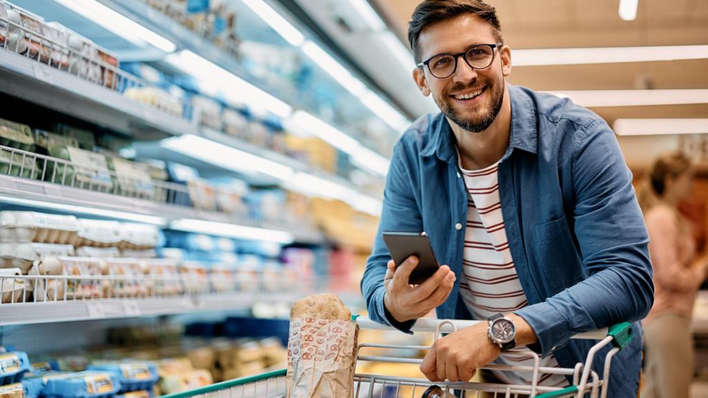 Un joven realizando la compra en el super con ayuda de una app.