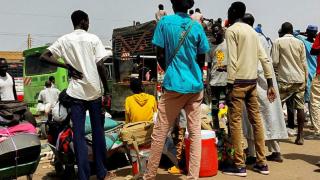 Un grupo de personas espera en Jartum, la capital de Sudán, para huir del país.