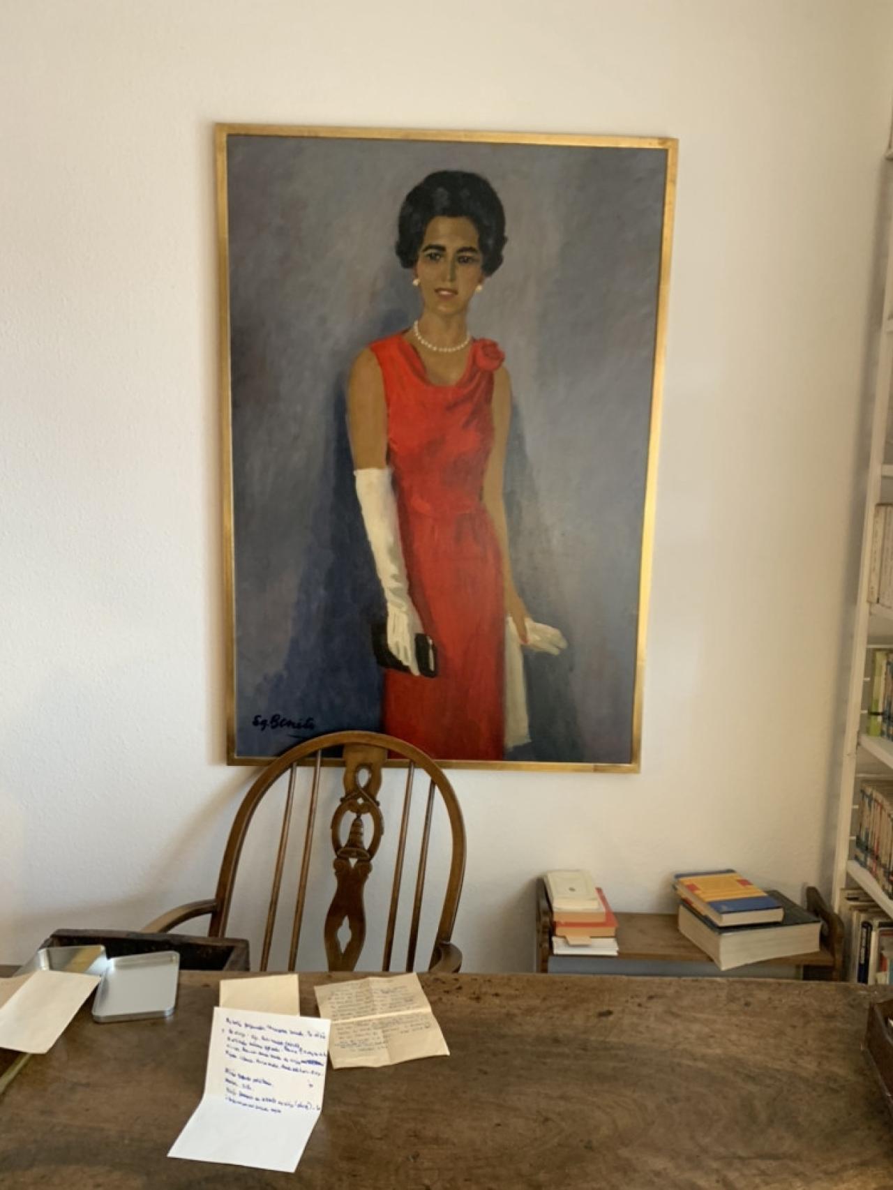Miguel Delibes escribía con el retrato de señora de rojo sobre fondo gris a su espalda.