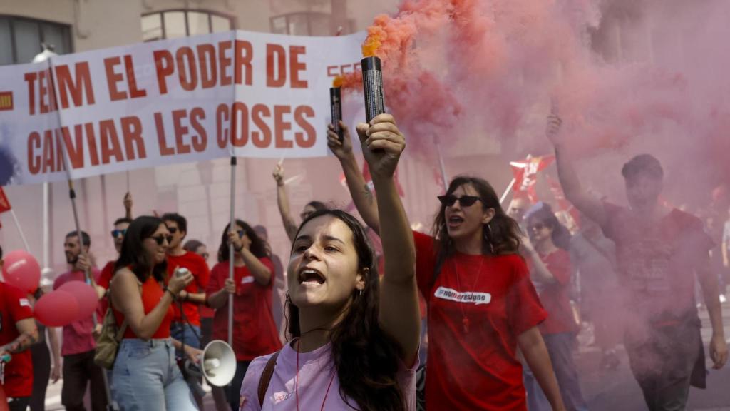 Varios jóvenes portan bengalas durante la manifestación convocada por los sindicatos CCOO y UGT-PV para celebrar el Día Internacional de los Trabajadores,