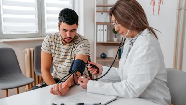 Una sanitaria toma la tensión a un paciente.