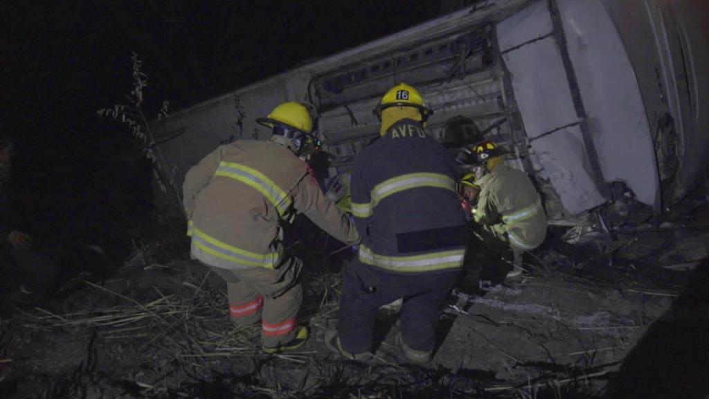 Un grupo de bomberos trabaja en el rescate de supervivientes del autobús que cayó por un barranco en Nayarit.