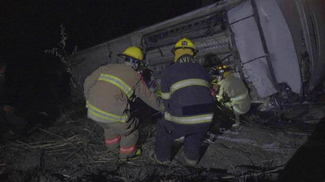 Un grupo de bomberos trabaja en el rescate de supervivientes del autobús que cayó por un barranco en Nayarit.