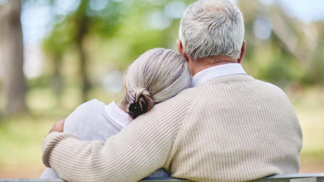 Una pareja de personas mayores en un banco.