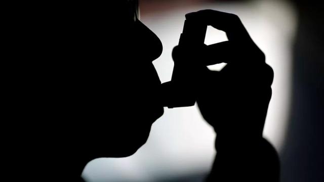 Una persona usando un inhalador para el asma.