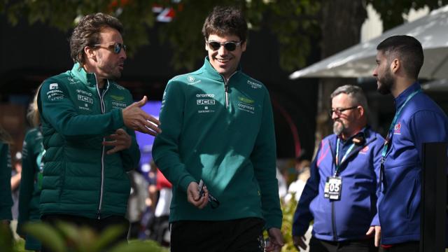 Fernando Alonso y Lance Stroll dialogan mientras dan un paseo.
