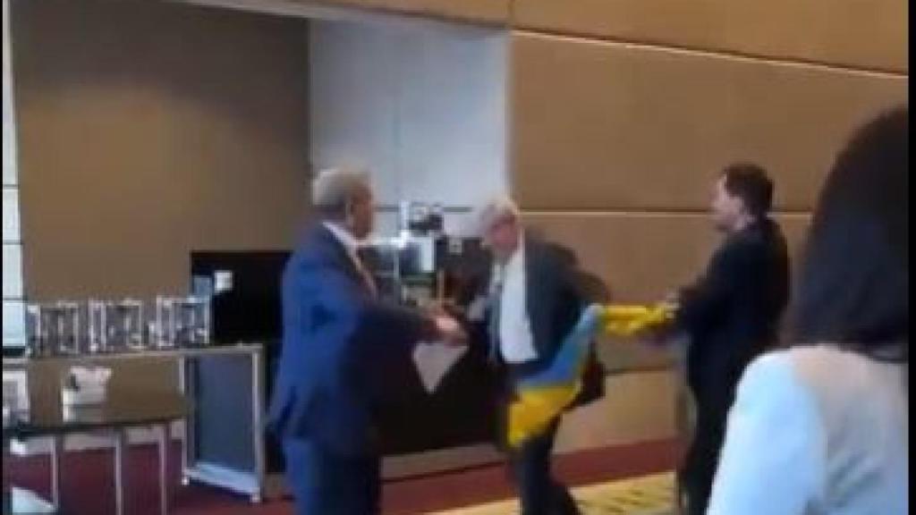 El representante ruso y el parlamentario ucraniano Oleksandr Marikovski, peleando por la bandera.