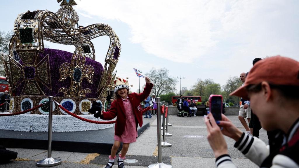 Una fanática de la monarquía británica posa junto a una imitación de la corona de San Eduardo antes de la Coronación del Rey Carlos III, en Londres.