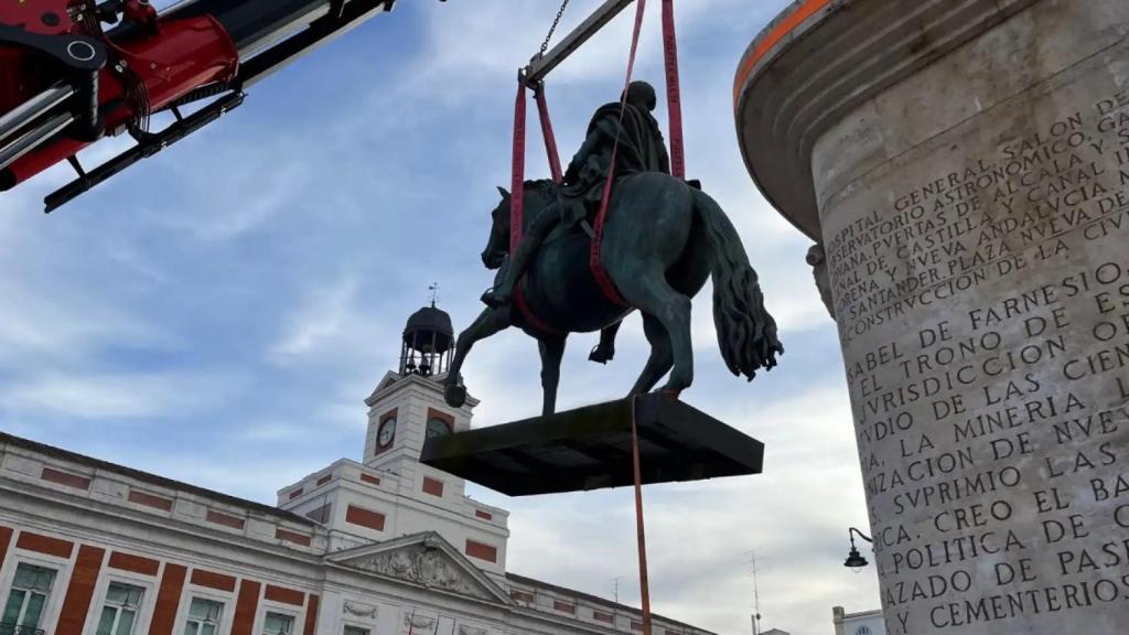 Imagen de la bajada de la estatua de Carlos III con la ayuda de una grúa.