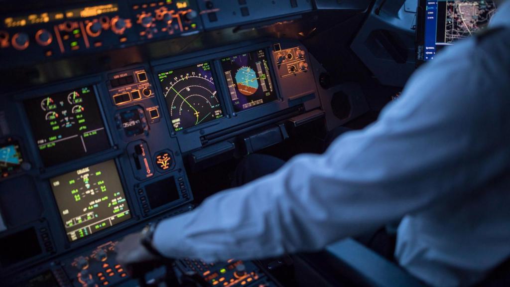 Piloto en la cabina de mandos manejando el avión.