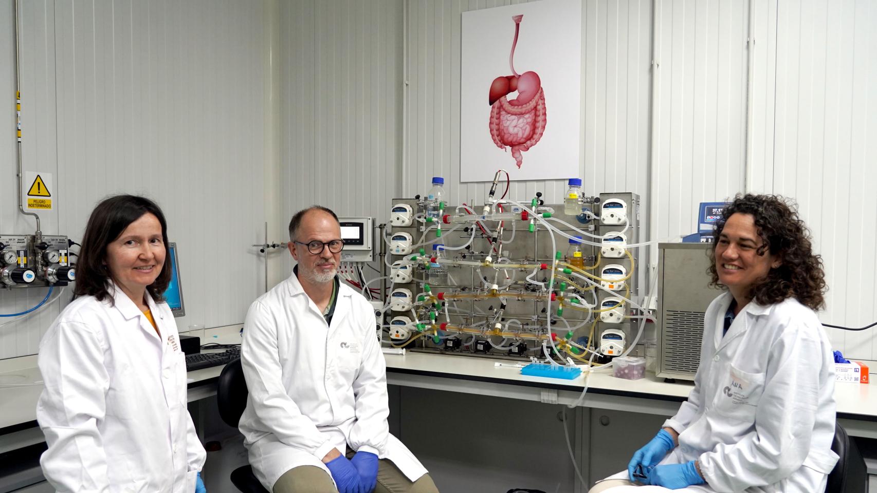 El investigador Daniel Rico y las técnicos María del Carmen García y Ana Belén Cano junto al simulador gastrointestinal del Itacyl.