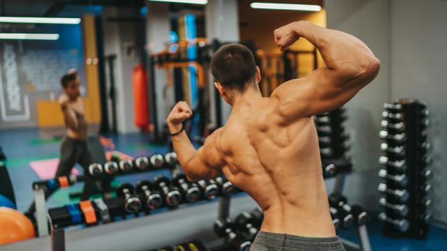 Imagen de archivo de una personas musculosa mirándose en el espejo de un gimnasio.