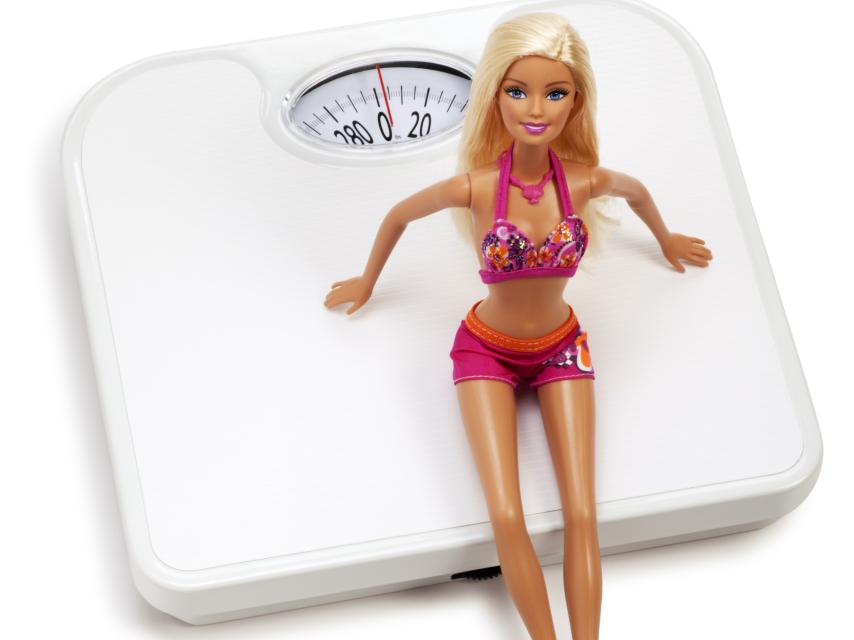 La muñeca Barbie sobre una báscula (Istock)