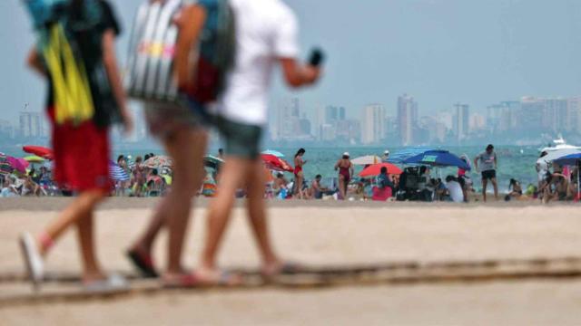 Varios jóvenes acceden a una playa en la costa alicantina, en imagen de archivo.