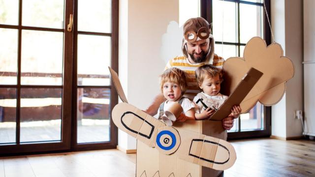 Imagen de archivo de un padre jugando con sus hijos pequeños.