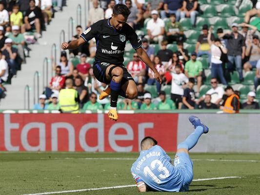 El centrocampista del Atlético de Madrid Sergio Reguilón y el portero del Elche Edgar Badía, durante el partido.