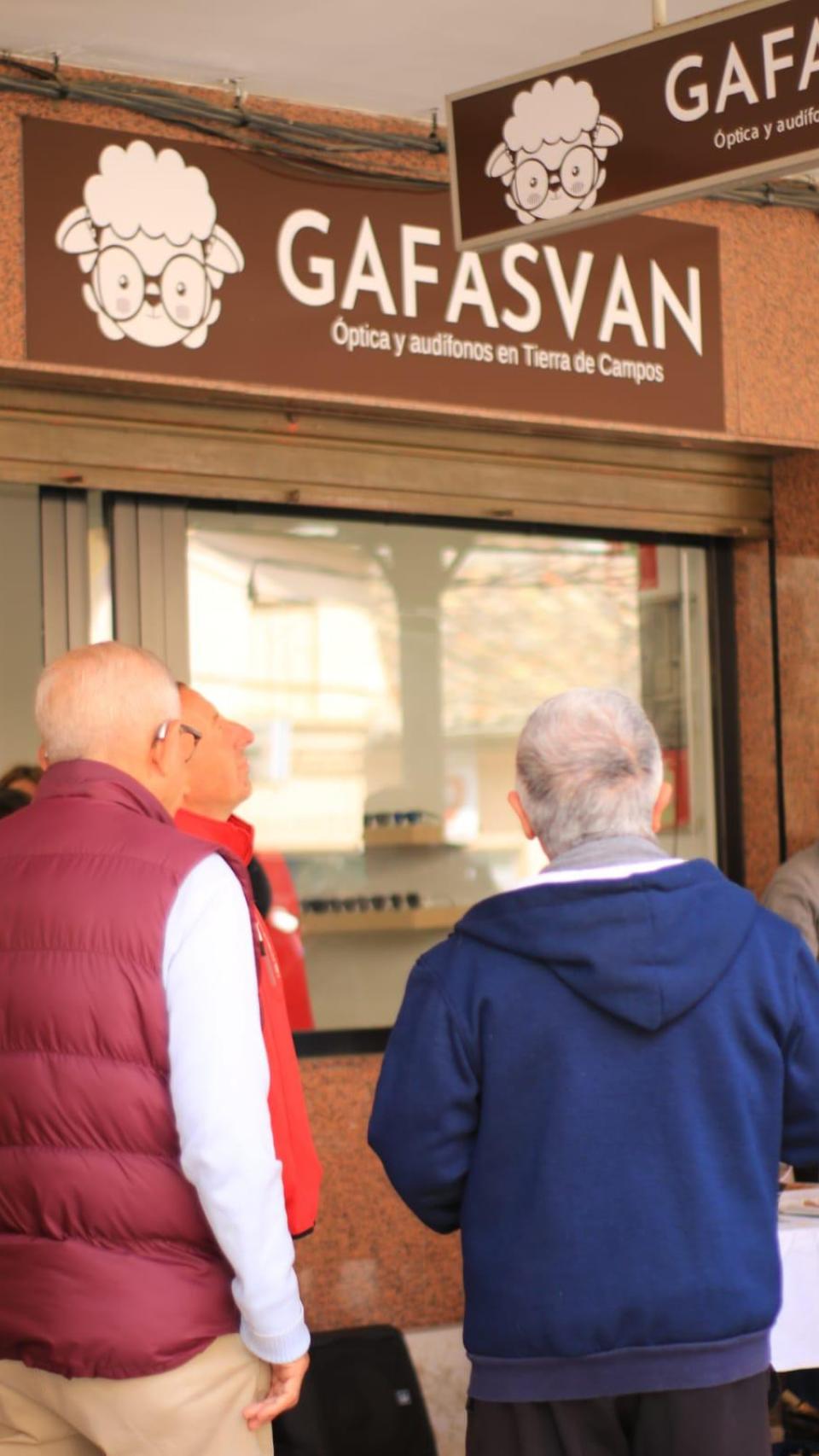 Varias personas miran el cartel de la nueva tienda en Villalón
