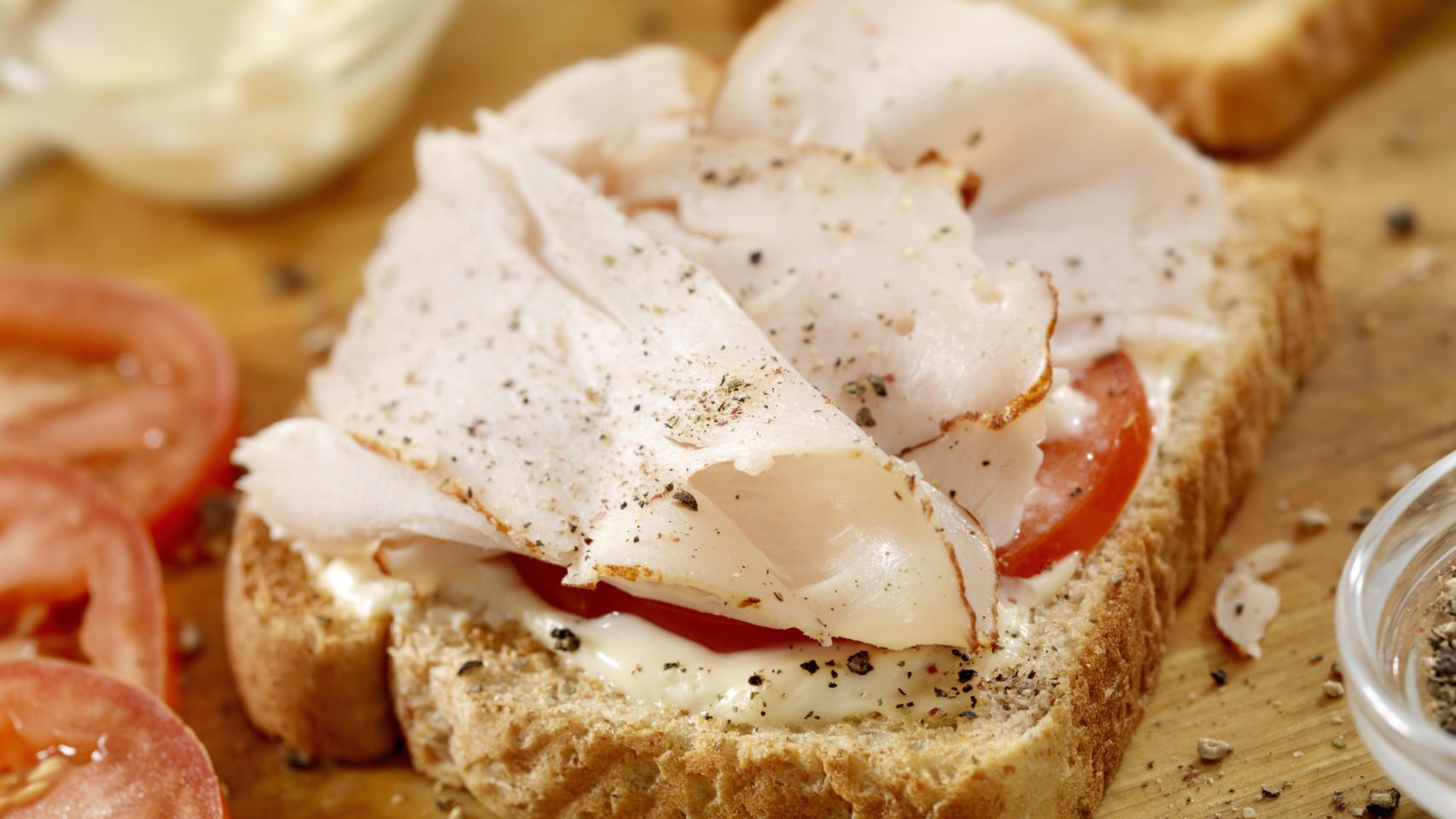 Una tostada de pavo con tomate.