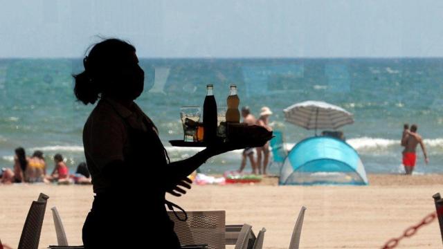Una camarera en un restaurante en primera línea de playa en la costa alicantina.