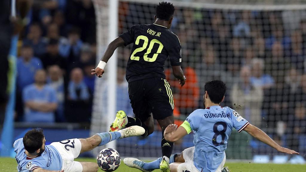 Vinicius recibe la entrada de Gundogan en un instante del encuentro.