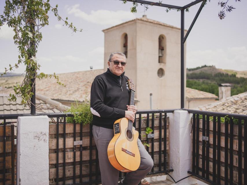 Ángel Corpa con la iglesia de su pueblo al fondo.