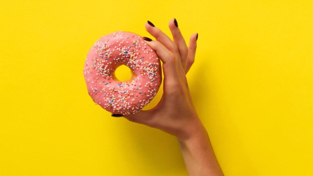 Una mujer, sujetando un 'donut'.
