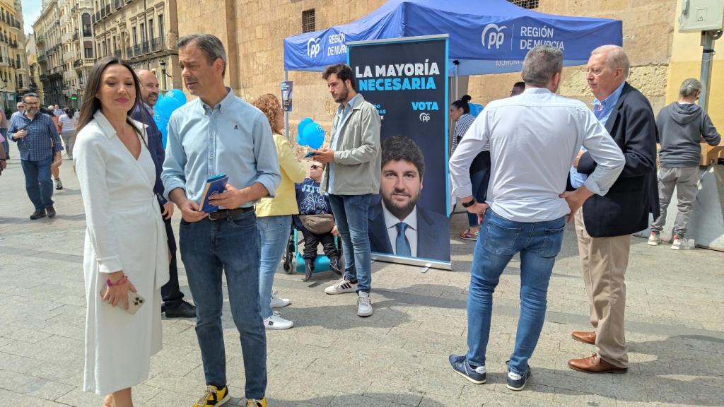 La número 2 del PP a la Asamblea Regional, la periodista Carmen Conesa, y el consejero de Presidencia, Marcos Ortuño, este domingo, en la plaza de Santo Domingo de Murcia, entregando propaganda electoral de Fernando López Miras.