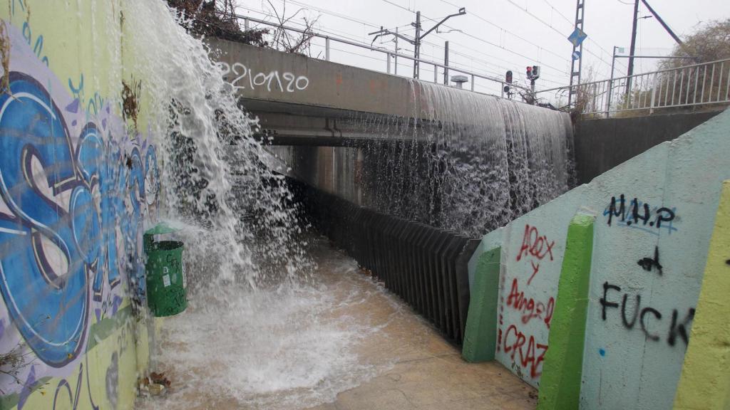 Vista genera del agua que cae en el paso inferior a la entrada de San Vicente desde la carretera de La Alcoraya que ha sido cortado por las intensas lluvias.