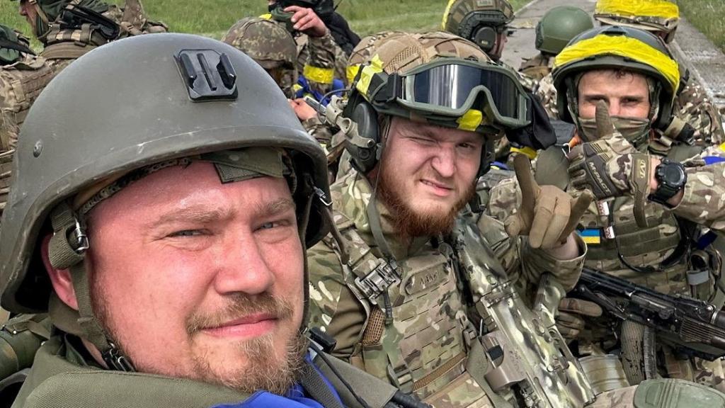 Miembros del Cuerpo de Voluntarios Rusos posan para una foto encima de un vehículo blindado en el cruce fronterizo de Gráivoron en Kozinka, región de Bélgorod (Rusia).