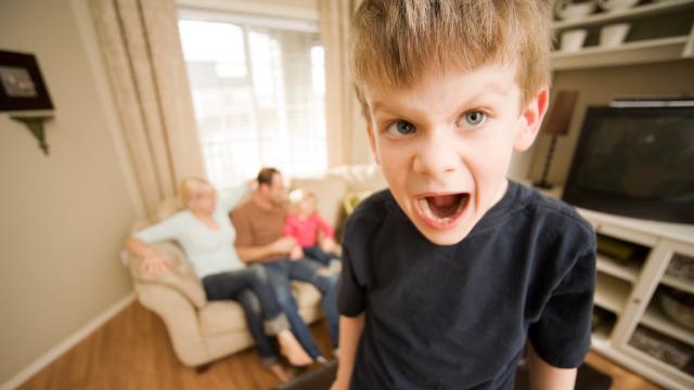 Un niño en plena rabieta con su familia en casa.