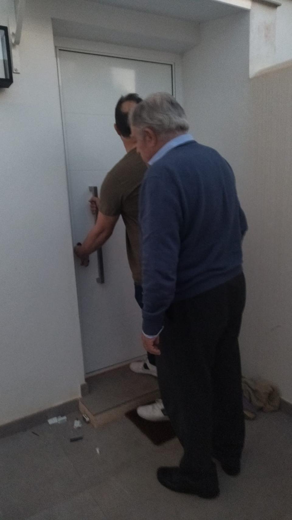 El exalcalde de Mojácar y exsenador, Bartolomé Flores, este miércoles, supervisando al cerrajero que estaba arreglando la puerta de la casa de su hijo, Francisco, tras ser reventada por la Guardia Civil.