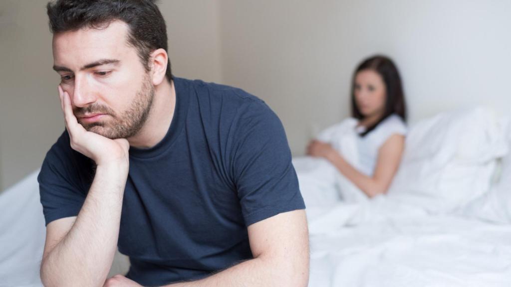 Un hombre con problemas junto a su pareja.