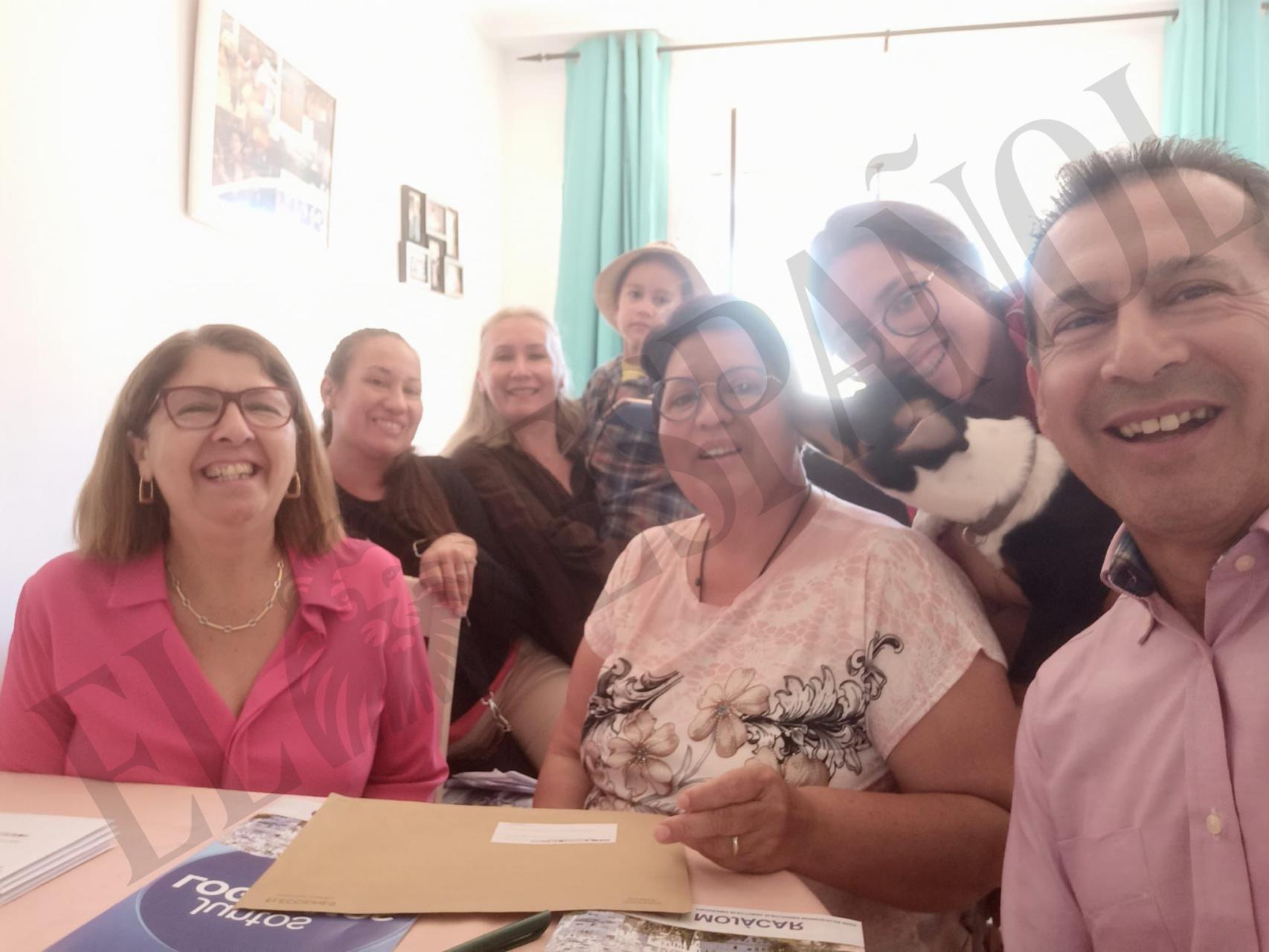 La alcaldesa del PP de Mojácar,  Rosa María Cano (1i), junto a la beneficiaria de la cesta de comida de Navidad y los supuestos sobres de voto por correo, en una imagen presuntamente tomada en mayo.