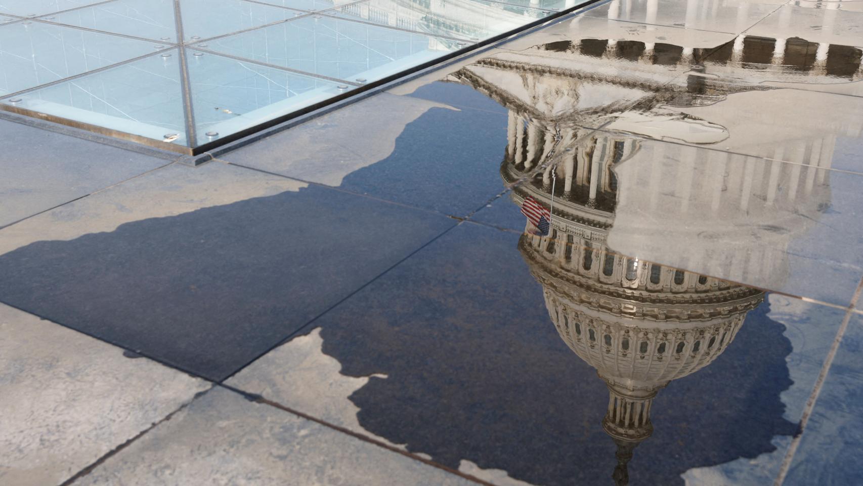 La cúpula del Capitolio de Estados Unidos se refleja en un charco de agua en Washington.