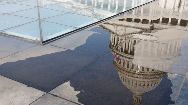 La cúpula del Capitolio de Estados Unidos se refleja en un charco de agua en Washington.