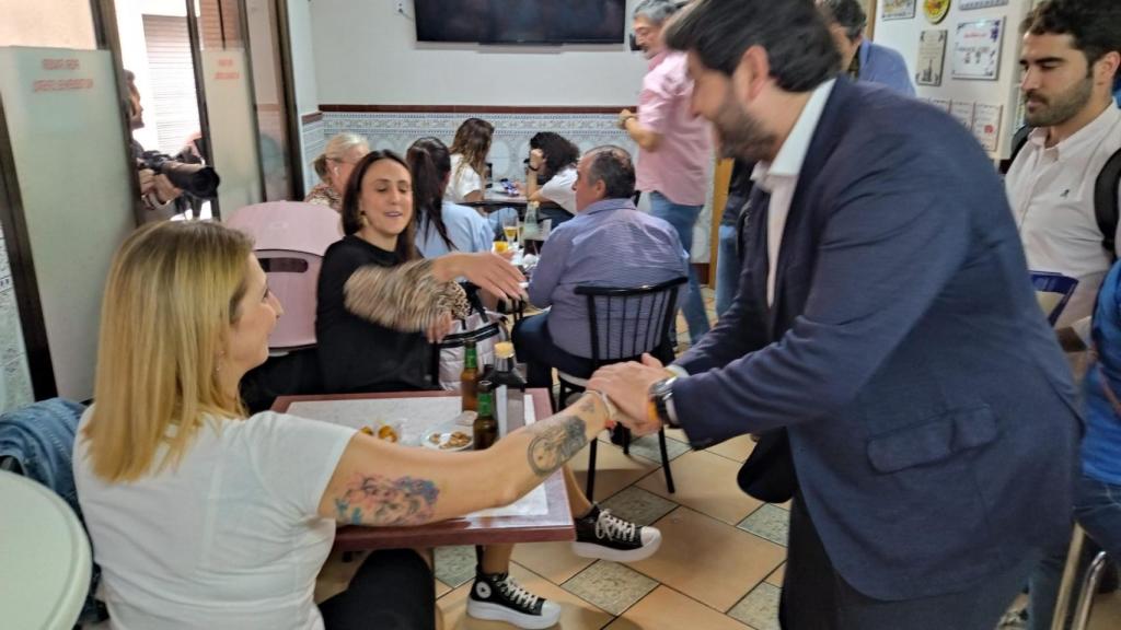 Dos clientas de la taberna saludando a López Miras, este viernes.