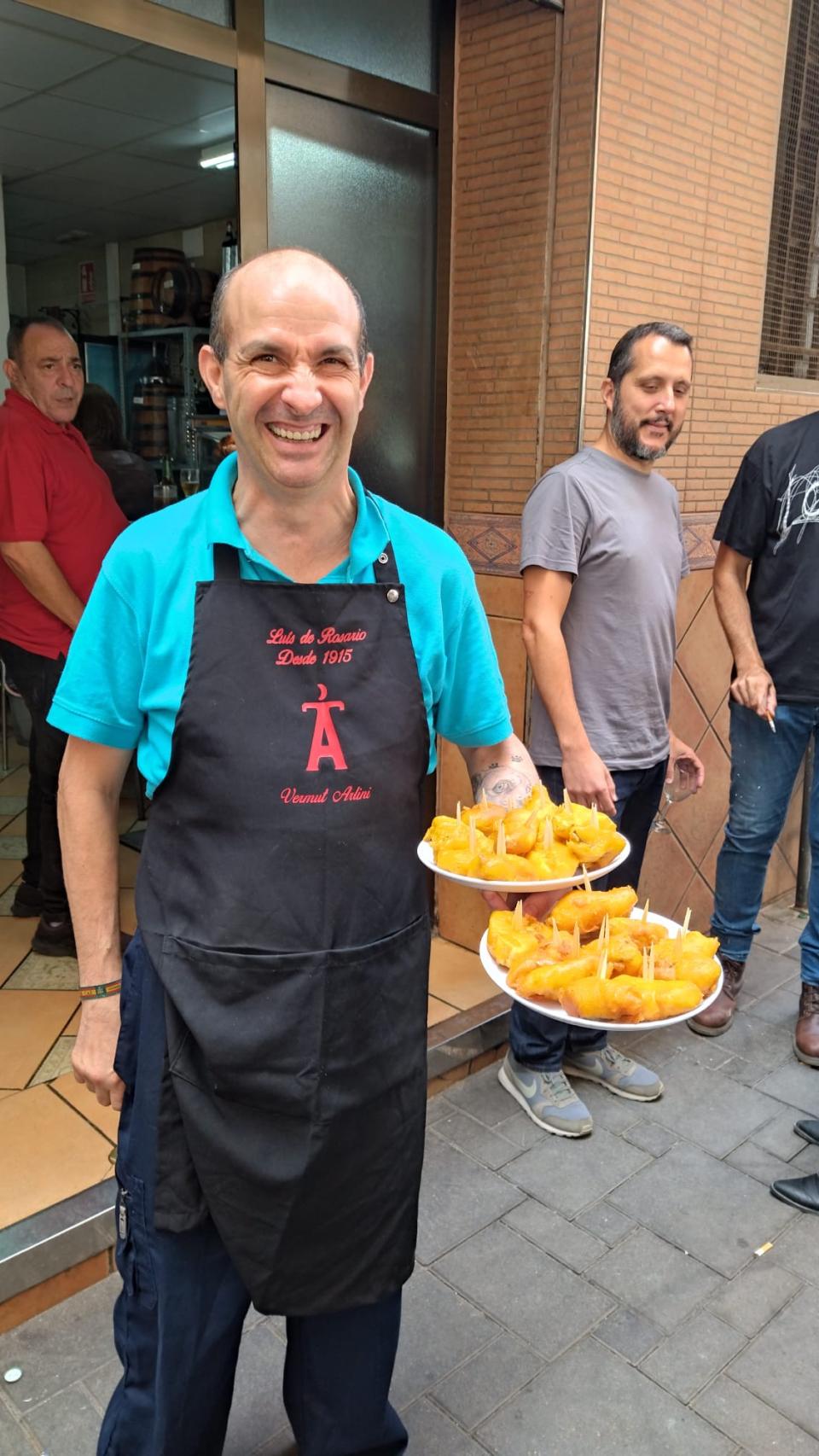 Un camarero del Bar Luis de Rosario de Murcia, este viernes, sacando unas raciones de bacalao para los periodistas y los miembros de la candidatura del PP.