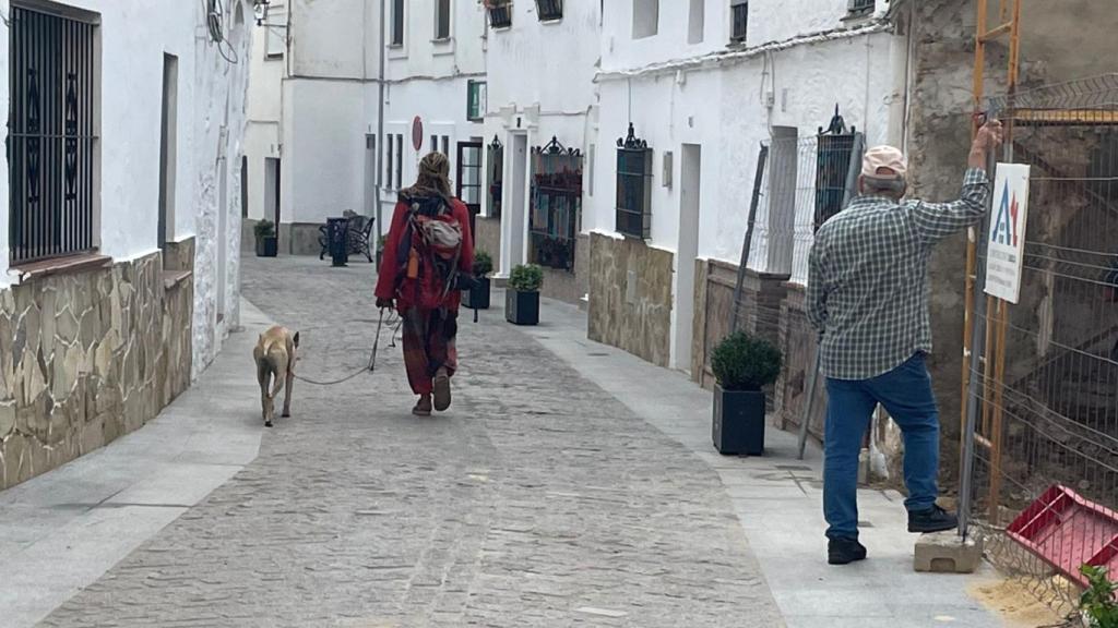 Un obrero mira a un hippie que pasea por Benaocaz.