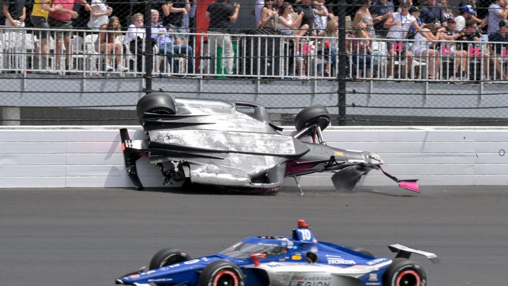 Alex Palou, con un coche accidentado al fondo.