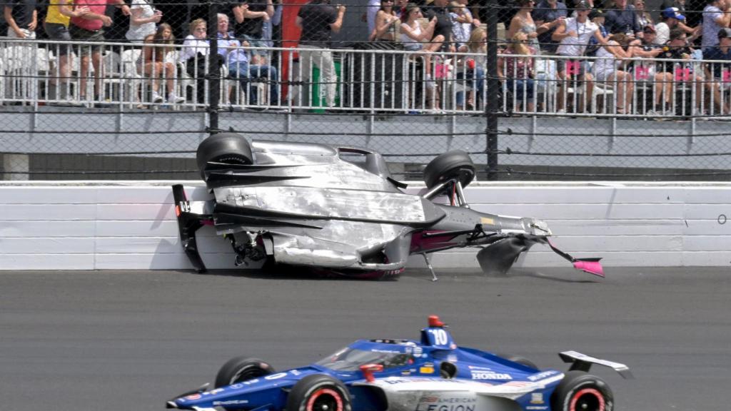 Alex Palou, con un coche accidentado al fondo.