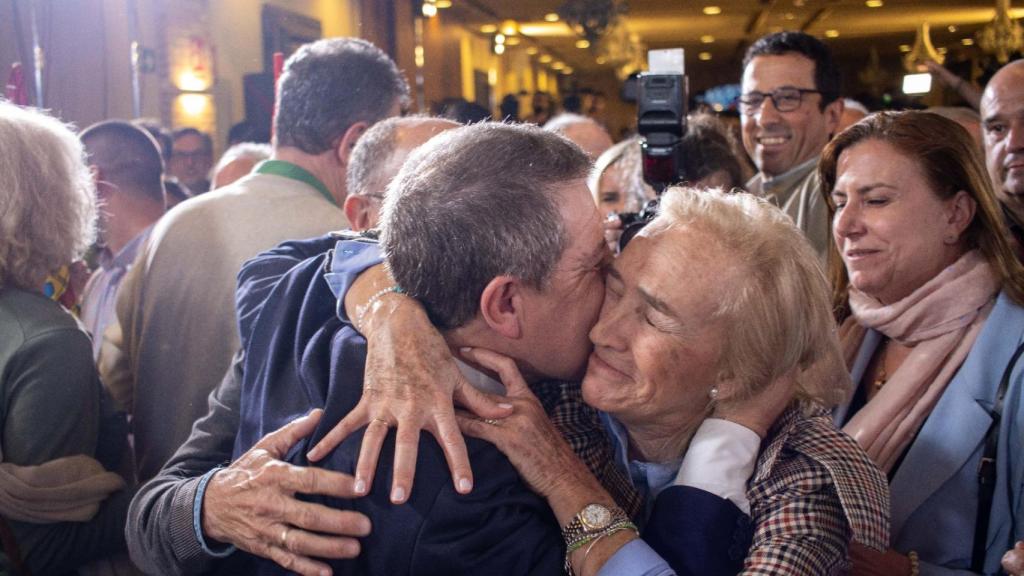 Emiliano García-Page abraza a una persona en la noche electoral