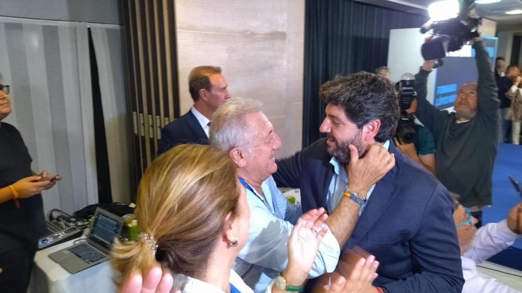 López Miras, este lunes de madrugada, siendo abrazado por los militantes que le esperaban en el Hotel NH Amistad de Murcia.