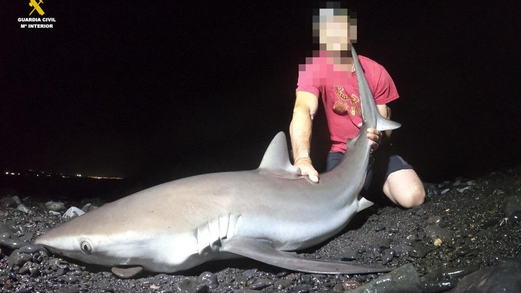 Imagen del detenido con un tiburón.